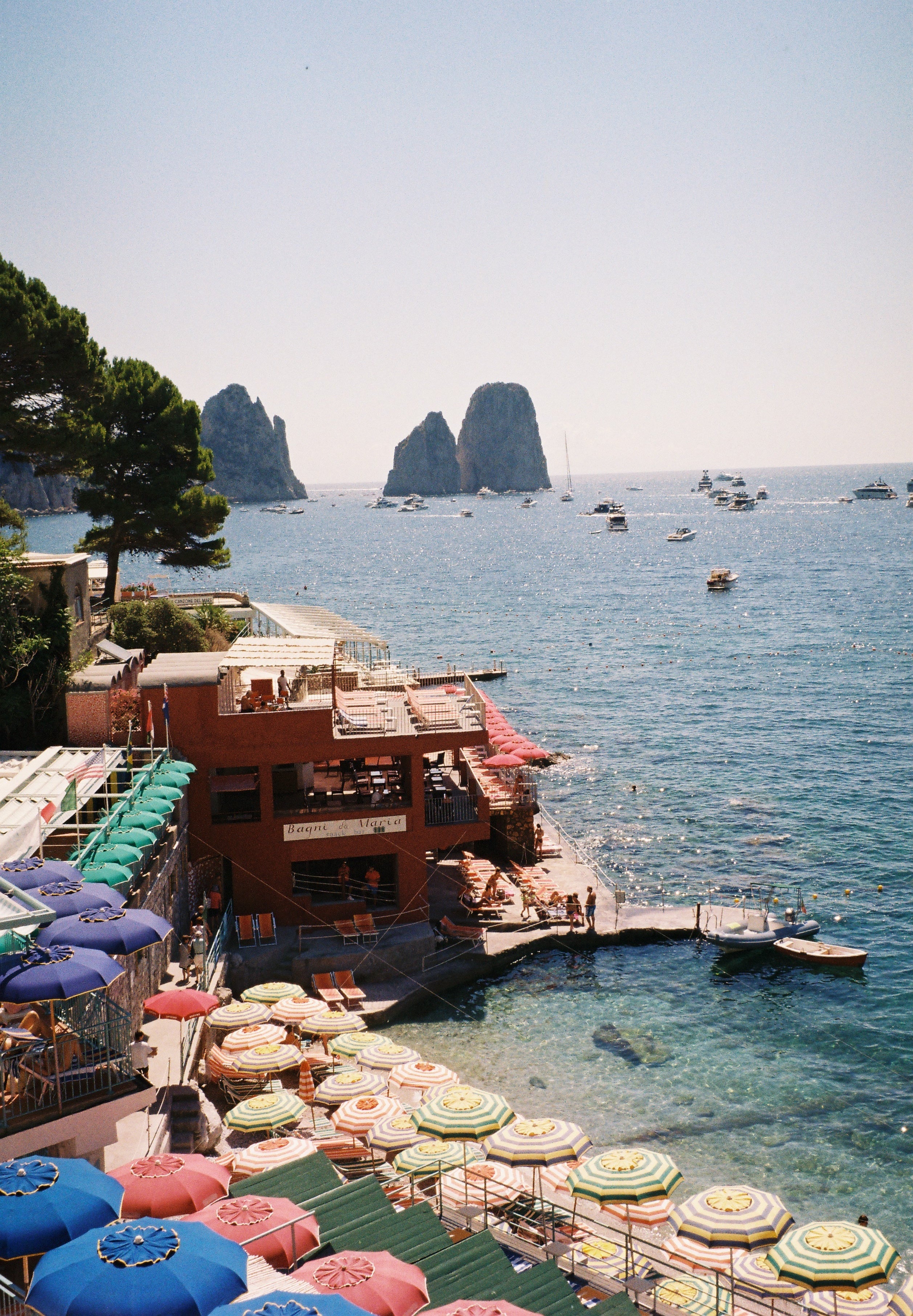 Marina Piccola, Capri, on 35mm film: striped beach umbrellas, Bagni da Maria and the Faraglioni rocks at sea